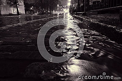 Rain water flowing on a cobblestone street in Helsinki Stock Photo