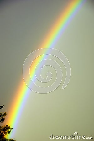 Rainbow against dark threatening sky Stock Photo