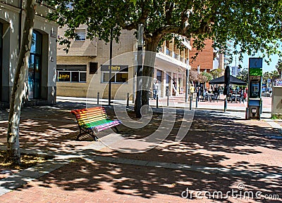 Rainbow coloured bench in sunshine. Editorial Stock Photo