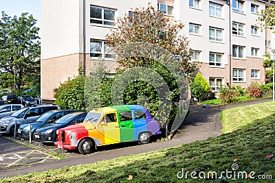 Rainbow coloured car parked in residential area of Glasgow Editorial Stock Photo