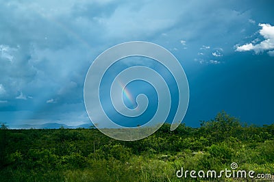 Rainbow dramatic stormy sky in blue and green colors Stock Photo