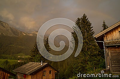 Rainbow above the firs, Alps of Austria Stock Photo