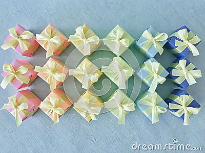 Rainbow gradient colors series of gift boxes arranged in rhombuses neatly on background of blue watercolor background. Stock Photo