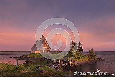 Rainbow on the lilac sky after a thunderstorm. Landscape of the White Sea with a small island, a wooden old house and a ruined bri Stock Photo