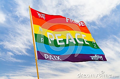 Rainbow multiolored peace flag wind flying against blue sky Stock Photo