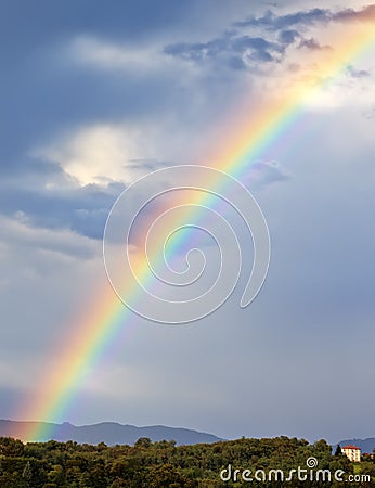 Rainbow over green hill Stock Photo