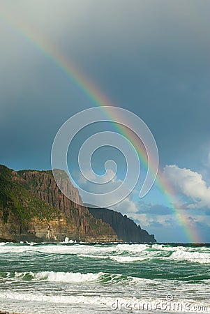 Rainbow over headland Stock Photo