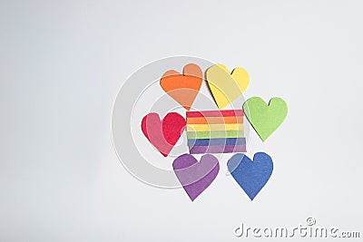 Rainbow paper hearts surrounding rainbow strips of paper. LGBT concept - image Stock Photo