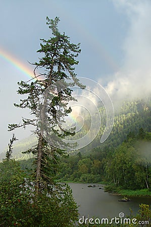 Rainbow after rain in the mountains by the river Stock Photo