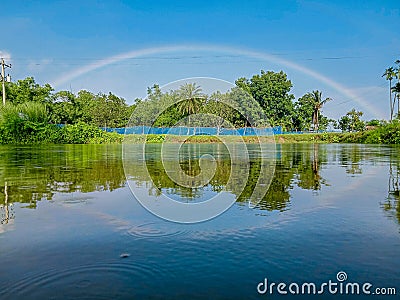 Rainbow reflected on blue River Water Stock Photo