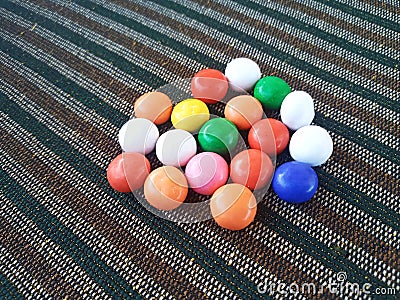 Rainbow Sugar Coated Round Chocolate Balls on the Colorful Carpet Stock Photo