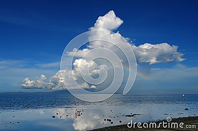 Rainbow and thunderstorm over a tropical island. Stock Photo