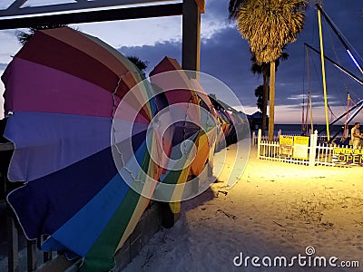 Rainbow umbrellas on the beach after sunset at clearwater pier, Florida Editorial Stock Photo