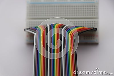 Rainbow wires or jumper wires connected to breadboard on white background. Colored cables for electronics Stock Photo