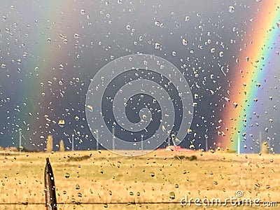 Raindrop glass with a rainbow in a field Stock Photo