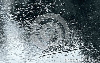 Raindrops background with sky reflection and water circles on asphalt Stock Photo