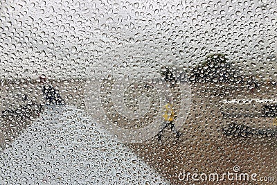 Raindrops on a plane window and man reflection in them Stock Photo