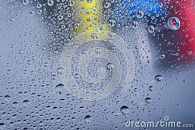 Water drops, rain drops or droplets on glass with push pins in the background. Stock Photo