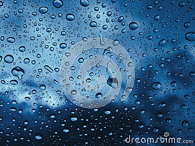 Raindrops water on the window glass against the dark clouds Stock Photo