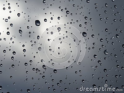 Raindrops on a window pane, on a background of heavily cloudy sky Stock Photo