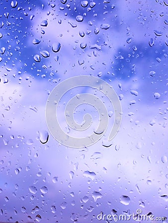 raindrops on the window in the window you can see the blue sky with white clouds Stock Photo
