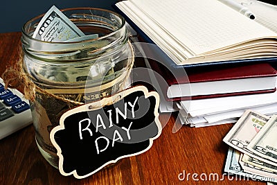 Rainy Day Fund label on the jar with money Stock Photo