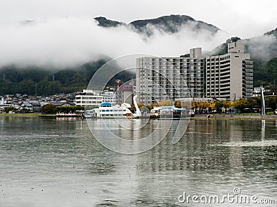 Rainy day at Kamisuwa with heavy clouds covering the mountains around Lake Suwako Editorial Stock Photo