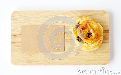 Raisin roll and note paper on wooden tray isolated on white back Stock Photo