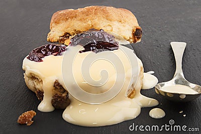 Raisin scone with fresh custard on slate Stock Photo