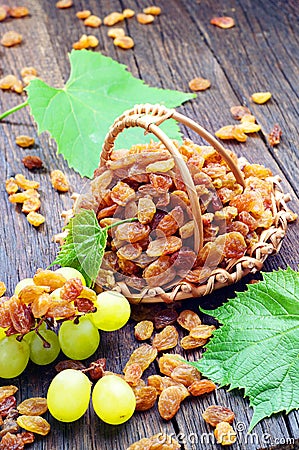 Raisin in a wicker basket and grape leaves Stock Photo