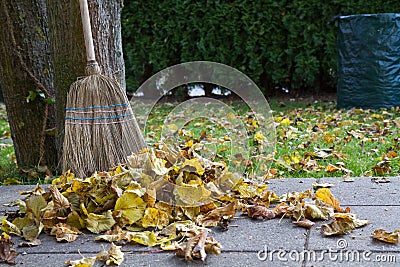 Raking autumn foliage with a broom Stock Photo