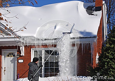 Raking Snow off the Roof Stock Photo