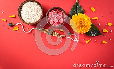 Raksha Bandhan, Indian festival with beautiful Rakhi and Rice Grains on red background. A traditional Indian wrist band which is Stock Photo