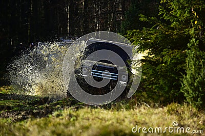 Rallying, competition and four wheel drive concept. Motor racing in autumn forest. Sport utility vehicle or SUV crossing Stock Photo