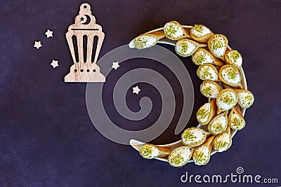 Ramadan kareem with qatayef arranged in shape of crescent moon. Traditional middle estern ramadan sweets. Iftar food concept. Stock Photo