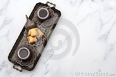 Ramadan treat and arabian hospitality concept with turkish baklava and mini coffee cups on authentic mediterranean metal tray Stock Photo
