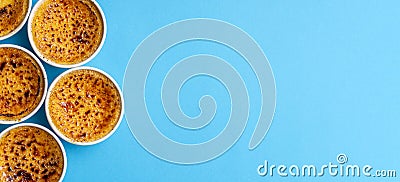 Ramekins bowls with creme brulee top view on blue background. French burned cream Stock Photo