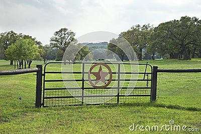 Ranch gate with pasture and trees in the Texas Hill Country Stock Photo