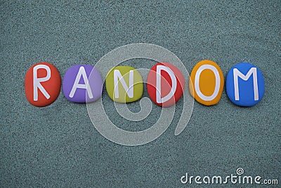 Random, creative word composed with multi colored stone letters over green sand Stock Photo