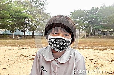 Picture of cute asian girls, wearing a white shirt, that has a black mask Editorial Stock Photo
