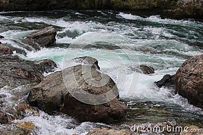 Rapid current Water flow at small shallow mountain river at summer day. Stones stick out of the clear water. Close up Stock Photo