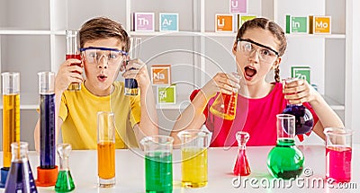 Rapturous mates making experiment with bright liquid at school Stock Photo