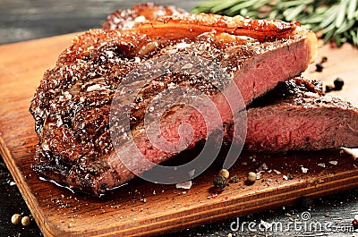 Rare New York strip steak on wooden board, selected focus Stock Photo