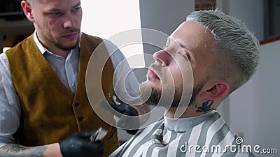 Rasieren des Bartes Friseurausschnittmänner ` s Gesichtshaar mit Barttrimmer am Friseursalon stock video Rasieren des Bartes Friseurausschnittmänner ` s Gesichtshaar mit Barttrimmer am Friseursalon stock video