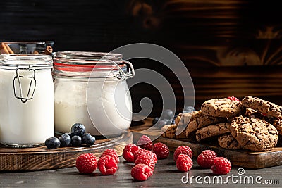 Raspberries, blueberries and homemade cookies placed on wooden platters Stock Photo