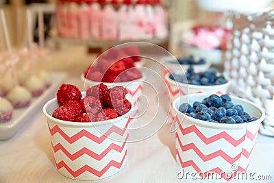 Raspberries and blueberries in paper cups Stock Photo