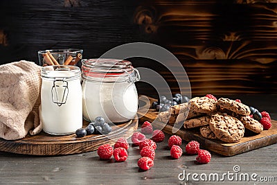 Raspberries in foreground, milk and cookies in backround Stock Photo