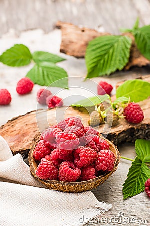 Raspberry in a bowl, berries and leaves on a shabby wood Stock Photo