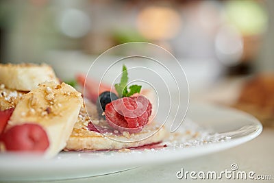 Raspberry close up with slices of banana, berries on a pancake sprinkled with powdered sugar, shallow depth of field Stock Photo
