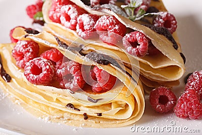 raspberry crepes with chocolate frosting macro on a plate. horizontal Stock Photo